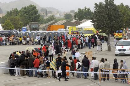 Cientos de ciudadanos hacen cola para que técnicos del Ayuntamiento de Lorca, de Cruz Roja y de Protección Civil comprueben los datos y la situación de cada uno de los 2.687 acogidos en el mayor de los tres campamentos instalados tras los terremotos.