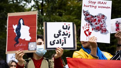Protesters hold placards during a rally against Iranian regime outside the House of Representatives in The Hague on September 23, 2022, following the death of an Iranian woman after her arrest by the country's morality police in Tehran. - Mahsa Amini, 22, was on a visit with her family to the Iranian capital Tehran, when she was detained on September 13, 2022, by the police unit responsible for enforcing Iran's strict dress code for women, including the wearing of the headscarf in public. She was declared dead on September 16, 2022 by state television after having spent three days in a coma. (Photo by Lex van LIESHOUT / ANP / AFP) / Netherlands OUT