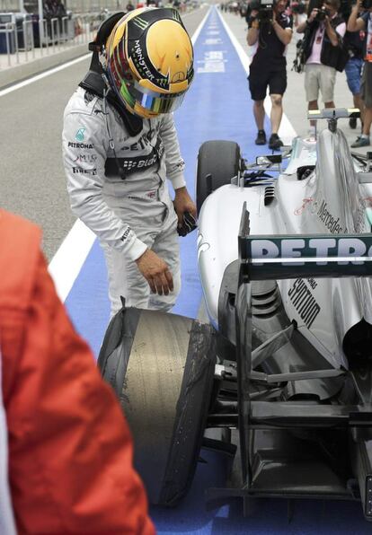 Hamilton observa la rueda dañada.