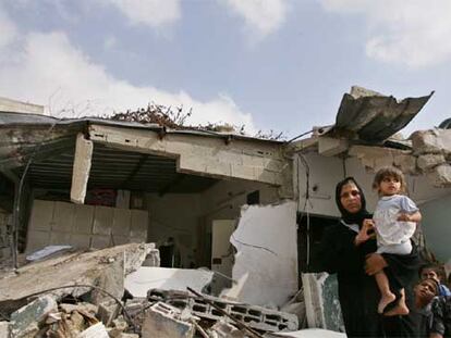 Una mujer palestina de Gaza y sus hijos, delante de las ruinas de su casa, destruida por el Ejército israelí.