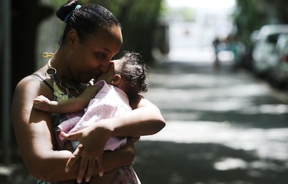 Brasileira carrega a filha afetada pelo vírus Zika.