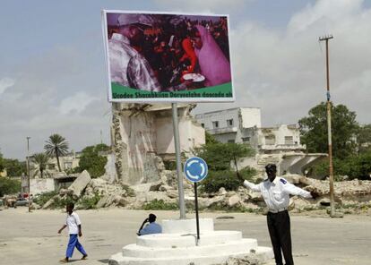 Un ni&ntilde;o somal&iacute; pasa junto a un cartel del actual presidente Sharif Sheij Ahmed, en Mogadiscio.