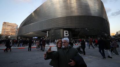 Dos aficionados del Real Madrid se fotografían en el exterior del estadio Santiago Bernabéu el 2 de diciembre de 2023.