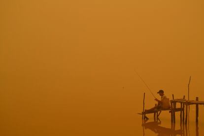 Un hombre pesca en el río de la ciudad de Palangkaraya (Indonesia), una de las más afectadas por los incendios en el sudeste asiático.