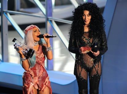 Cher sujeta su bolso hecho con carne fresca de Lady Gaga mientras la joven estrella recoge su premio durante la entrega de los Video Music Awards de la MTV en 2010. Gaga ha sido comparada con Cher en múltiples ocasiones por su imaginativa manera de vestir. Ambas grabaron 'The greatest thing' para el último álbum de Cher, pero Gaga, no satisfecha con el resultado, vetó su publicación.