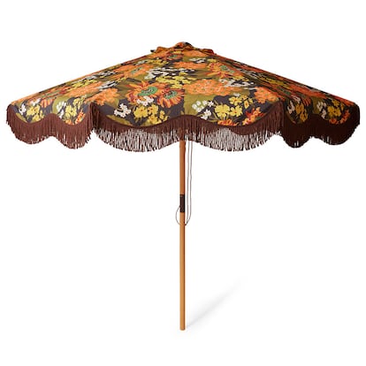 En los años cincuenta y sesenta reaparecieron en clave pop, coloridas, con flores, de plástico y con volantes. En la imagen, la sombrilla retro Flourish, de HK Living, presenta estampado floral en marrón oscuro se combina con un forro en contraste y borlas decorativas para darle un aire ultrarretro.