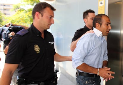La policía conduce al kurdo Hokman Joma, de 27 años, ante el juez tras llevar desde febrero en prisión por lanzarle un zapato al primer ministro turco, Recep Tayyip Erdogan, durante la visita de este a Sevilla.