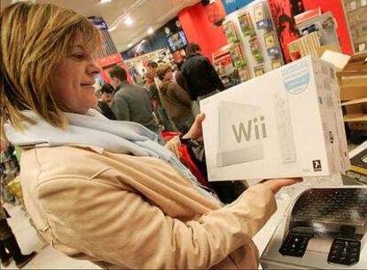 Una señora sujeta la caja de la consola de Nintendo Wii en unos grandes almacenes para comprársela.