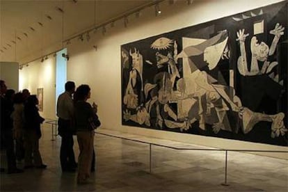 Visitantes del Reina Sofía contemplan el <i>Guernica</i> ayer en Madrid.