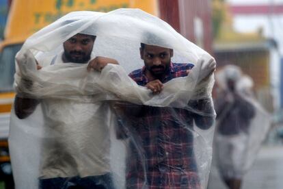 Dos personas se protegen de la lluvia durante la llegada del ciclón Nivar, en Chennai (India). El ciclón considerado por los servicios meteorológicos indios como una "tormenta tropical muy fuerte", alcanzará tierra con vientos previstos de 120 kilómetros por hora y algunas ráfagas de hasta 145.