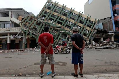 Dos hombres miran un edificio destruido en la ciudad de Portoviejo (Ecuador), casi una semana después de que un fuerte terremoto de magnitud 7,8 grados en la escala Richter golpeara el país, el 21 de abril de 2016.