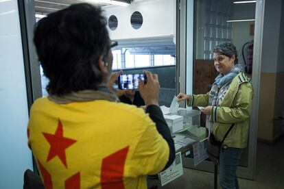 Un home amb una samarreta 'estelada' fotografia la seva parella mentre vota.