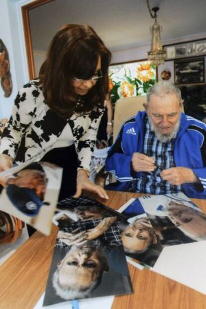 Cuba's former President Fidel Castro signs pictures for Argentinian President Cristina Fernández de Kirchner in Havana in this handout image.