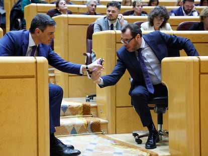 Desde la izquierda, el presidente del Gobierno, Pedro Sánchez mira un teléfono móvil que le muestra el ministro de Transportes, Óscar Puente, este miércoles en el Senado.