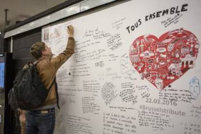 Un joven firma en el muro del recuerdo en la estación de Maelbeek.