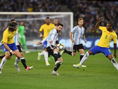 Leo Messi, de la selección argentina, lucha por el balón contra Fernando Roza en el partido amistoso.