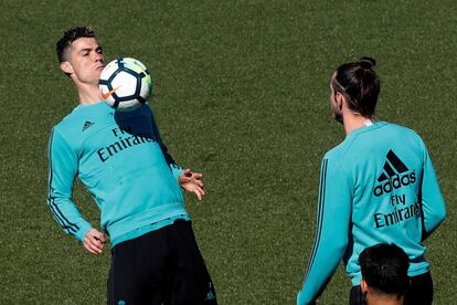 Cristiano Ronaldo pelotea con Bale en el entrenamiento de este viernes.