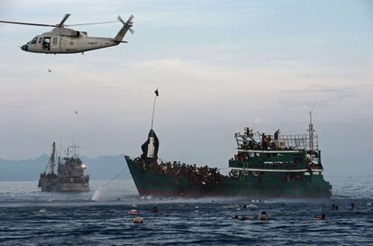 Las autoridades tailandesas prometieron enviar mecánicos al barco para que reparen el motor de la embarcación y que pueda continuar su camino, según el medio Phuketwan. En la imagen, varios inmigrantes Rohingya se tiran al agua para recoger paquetes de alimentos lanzados desde un helicóptero por el Ejército tailandés.