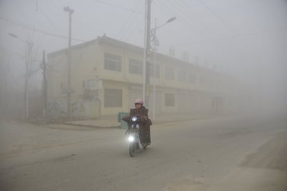 Una persona en motocicleta entre la niebla tóxica de Liaocheng (China), el 20 de diciembre de 2016.
