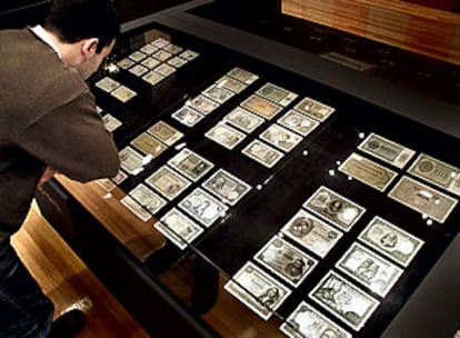 Un visitante contempla billetes antiguos en una exposición en el Centro Cultural de Caixa de Girona.