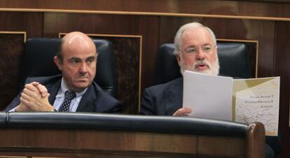 El ministro de Economía, Luis de Guindos, junto al ministro de Agricultura, Miguel Arias Cañete, en la sesión de control al Gobierno de hoy.