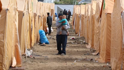 Un hombre pasea a un beb en un campamento de desplazados en Ciudad de Gaza.