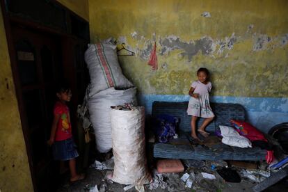 En la foto, Angel Khasanah Nova Putri, una niña de 8 años, se esconde mientras juega con su amiga en Bangun, Mojokerto, Java oriental, Indonesia.