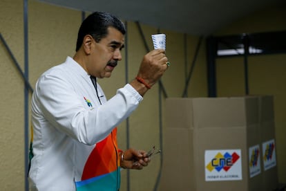 Venezuela's President Nicolás Maduro shows his ballot during a referendum over Venezuela's rights to the potentially oil-rich region of Esequiba in Guyana, in Caracas, Venezuela, December 3, 2023.