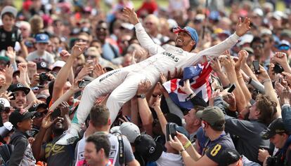 El británico Lewis Hamilton celebra con los aficionados la victoria en el GP de Inglaterra, en el circuito de Silverstone.