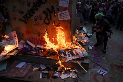 Dos mujeres queman varias pancartas usando aerosoles y fuego, en la base de la estatua de Luis Carlos Galán.