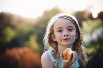 Una niña come una manzana.