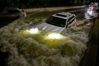 Un vehículo atraviesa una calle inundada en Brooklyn.