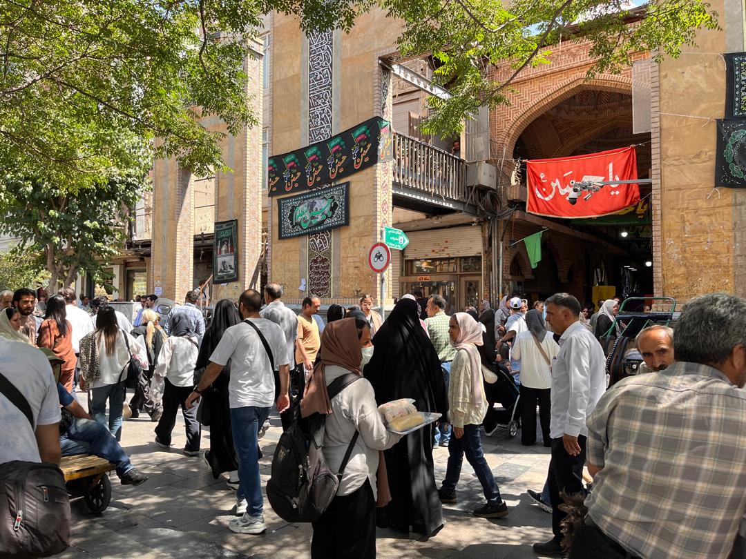 Marzieh, de espaldas a la cámara, con una mochila llena de bocadillos en el bazar tradicional de Teherán.