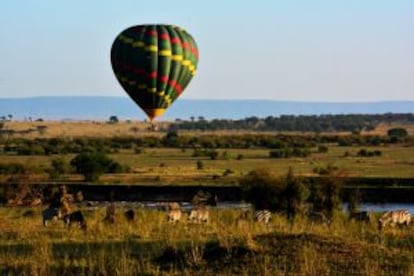 Cebras en el parque nacional de Serengeti, con un globo aerostático al fondo.