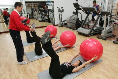 Empleados de Coca-Cola España hacen ejercicio en el gimnasio de la empresa.