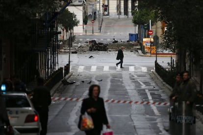 Restos del coche bomba que ha explotado en una calle del centro de Atenas, sin causar daños mortales.