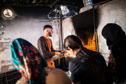 Dentro de la panadería autogestionada mientras se hornea el pan. Un chico que vive en una de las aldeas vecinas ayuda a las aldeanas a hornear.