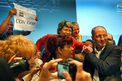 El presidente valenciano, Francisco Camps, saluda a asistentes al mitin organizado por el PP en el Palacio de Congresos de Valencia.