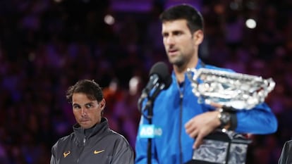 Nadal observa Djokovic durante a cerimônia de premiação em Melbourne.