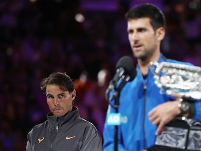 Nadal observa Djokovic durante a cerimônia de premiação em Melbourne.