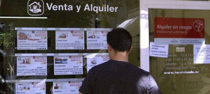 Escaparate de una inmobiliaria en Madrid con anuncios de pisos en venta.