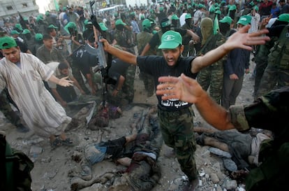 Palestinian militants and Hamas supporters run towards the scene as bodies lie in the street following an explosion during a demonstration by the group at the Jabalia refugee camp in the northern Gaza Strip, Friday, Sept. 23, 2005.