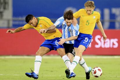 Andre Santos y Lucas Leiva tratan de impedir el avance de Messi.