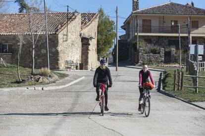 El panorama muta diametralmente a media hora de coche, en Sotosalbos, cercano a las montañas del norte de la Comunidad de Madrid. Allí la renta asciende a casi 20.000 euros por persona, entre los tramos más pudientes de España, y abundan los turistas o los propietarios de segundas residencias que buscan paz y tranquilidad en Segovia. En la imagen, una pareja se mueve en bicicleta por estos parajes calmados.