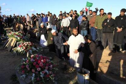 Libios leales a Gadafi asisten al acto organizado por el régimen para enterrar a las supuestas víctimas de los bombardeos aliados.