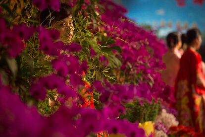 Mujeres de Corea del Norte, vestidas con sus trajes tradicionales, esperan guiar a los visitantes durante la exposición de flores en Pyongyang.