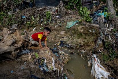 Un niño juega entre los escombros y el caño de aguas fecales del asentamiento 12 de septiembre, en Tibú, Colombia, a finales de agosto.