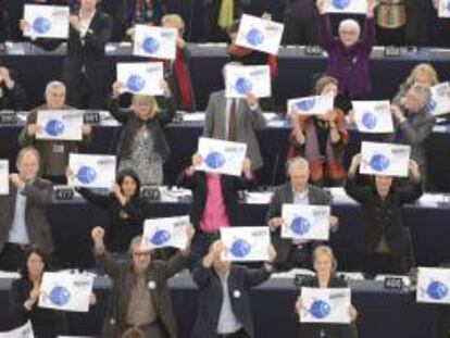 Miembros del Partido Verde muestran pancartas con la imagen de un pez tras la votación sobre la protección y conservación de los recursos pesqueros.