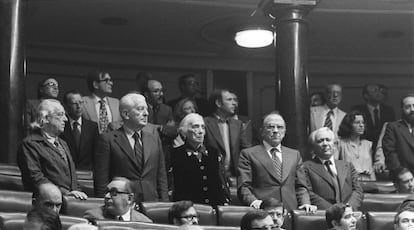 Los diputados del Partido Comunista, levantados en sus escaños del congreso durante el pleno en el que se aprobaron las dimensiones de los grupos para formar grupo parlamentario. En la foto, en la primera fila, de pie, de izquierda a derecha: Rafael Alberti, Gregorio López Raimundo, Dolores Ibarruri 'Pasionaria', Santiago Carrillo e Ignacio Gallego. Detrás de Ibarruri, semioculta, Pilar Brabo. En la fila trasera: Jordi Solé Tura (izquierda) y Ramón Tamames (segundo por la izquierda).