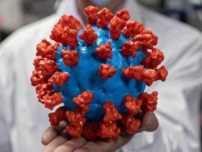Un científico chino sostiene una réplica del coronavirus.